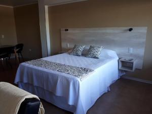 - une chambre avec un grand lit blanc et 2 oreillers dans l'établissement Perito Moreno - 3ro C, à Puerto Iguazú