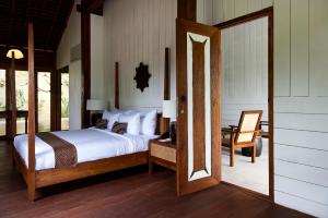 a bedroom with a bed and a table with a chair at Kalapa Boutique Resort & Yoga in Canggu