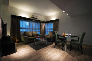 a living room with a couch and a table at Crown Regency Serviced Suites in Kuala Lumpur