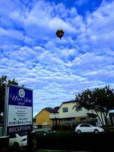 a kite is flying in the sky above a sign at Ulster Lodge Motel in Hamilton