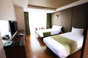 um quarto de hotel com duas camas e uma televisão em Sobaeksan Punggi Spa Resort em Yeongju