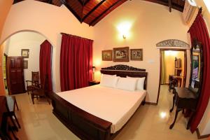 a bedroom with a large bed with red curtains at The Castle in Katunayake