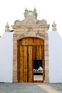 a wooden door in a building with a stone wall at Quinta da Lapa in Manique do Intendente