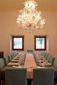 a long table in a room with chairs and a chandelier at Quinta da Lapa in Manique do Intendente