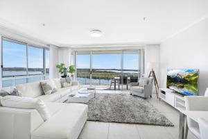 a living room filled with furniture and a large window at The Duporth Riverside in Maroochydore