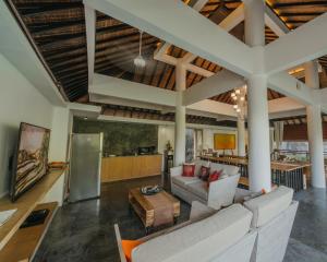 una sala de estar con un sofá y una mesa en La-Meli Villas Ubud, en Ubud