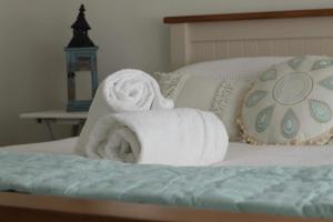 Seaview Cottage في Mokau: كومة من المناشف موضوعة فوق السرير
