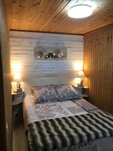 a bedroom with a bed with two lamps on two tables at Le Chalet du Lac - Domaine de la Goujonne in Saint-Sauveur-lès-Bray +35 photos