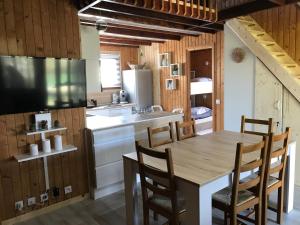 a kitchen with a table and chairs and a sink at Le Chalet du Lac - Domaine de la Goujonne in Saint-Sauveur-lès-Bray