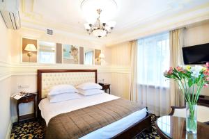 een hotelkamer met een bed en een vaas met bloemen bij Zvezda Hotel in Irkoetsk