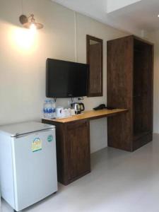 Il comprend une cuisine équipée d'un réfrigérateur et un bureau avec une télévision. dans l'établissement Baan Ton Chan, à Chao Lao Beach