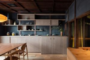 a kitchen with wooden cabinets and a wooden table at Nazuna Kyoto Gosho in Kyoto