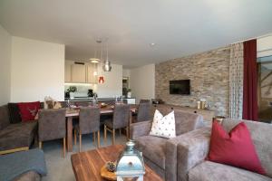 a living room with a couch and a table at Village Park Suites by VAYA inklusive Zell am See Kaprun Sommer Karte in Zell am See