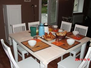 a dining room table with a white table cloth and food on it at Chambres d'hôtes vue panoramique proche de Carcassonne in Villardonnel