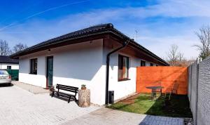 una pequeña casa blanca con un banco y una mesa en Apartmán Esser, en Milovice