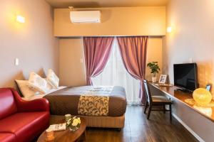 a hotel room with a bed and a desk at Mr. Kinjo in Ishikawa Inter in Uruma