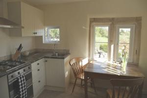 een keuken met een tafel en stoelen en een raam bij Hope Cottage in Stroud