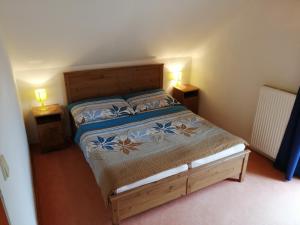 a bedroom with a bed with two lamps on two tables at Apartment Veronika in Přední Výtoň