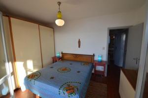 a bedroom with a bed with a blue comforter at Villa Ripa dei Carrai by Agenzia SolturElba in Capoliveri