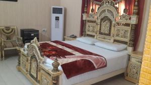 a bedroom with a large bed with an ornate headboard at Holiday Inn Guest House in Kalar Goth