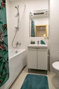 a white bathroom with a sink and a mirror at Raugyklos g. apartment in Vilnius
