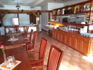 Un restaurante con mesas y sillas de madera y un bar. en Apartman Kuka Tatranská Lomnica, en Tatranská Lomnica