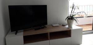 a flat screen tv sitting on top of a white cabinet at Villa SCIROCCO Madeira - Ocean View in Machico