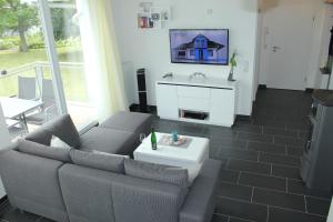 a living room with a couch and a tv at Küstenzauber 20 in Großenbrode