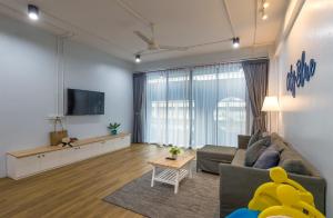 a living room with a couch and a tv at Otter House in Krabi