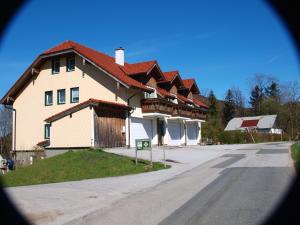 une grande maison avec un toit rouge dans une rue dans l'établissement Ferienhof Kehlbauer, à Hof bei Salzburg