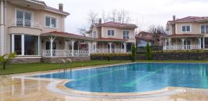 a large house with a swimming pool in front of a house at PALACE KIRKPINAR in Sakarya