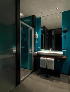 La salle de bains est pourvue d'un lavabo, d'une douche et d'un miroir. dans l'établissement Fletcher Hotel-Restaurant Parkstad- Zuid Limburg, à Kerkrade