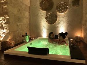 un hombre y una mujer en una bañera en Le Fornaci Imperial Lodge & Spa, en Gravina in Puglia