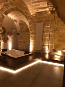 Habitación con bañera en una pared de ladrillo. en Le Fornaci Imperial Lodge & Spa, en Gravina in Puglia