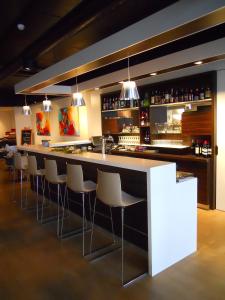 - un bar avec tabourets de bar blanc dans un restaurant dans l'établissement Fletcher Hotel-Restaurant Parkstad- Zuid Limburg, à Kerkrade