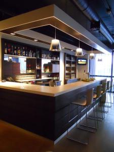 a kitchen with a bar and a counter with wine bottles on it at Fletcher Hotel-Restaurant Parkstad- Zuid Limburg in Kerkrade