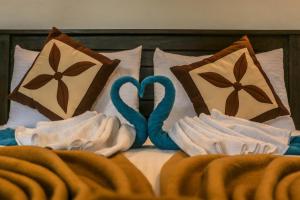 a bed with two towels and two hearts on it at Green Leaf Resort in Ella