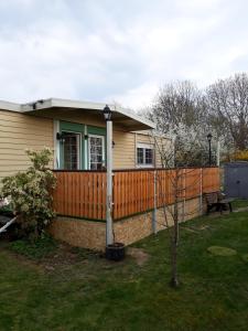 a house with an orange fence in a yard at Chalet am IJsselstrand in Doesburg