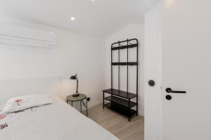 um quarto branco com uma cama e uma mesa em Suprema Lofts III em Lisboa