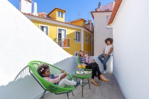 um grupo de pessoas sentadas em cadeiras numa varanda em Suprema Lofts III em Lisboa