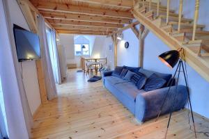 a living room with a blue couch and a staircase at Apart-Invest Apartament Alter Ego in Szklarska Poręba