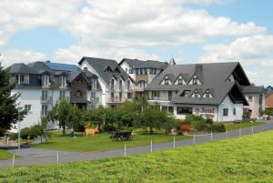 a row of houses with a park in front of it at Hotel zum Rehberg in Kastellaun