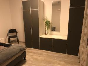 Schlafzimmer mit schwarzen Schränken und einem Spiegel in der Unterkunft Haus im Grünen in Lippstadt