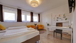 een slaapkamer met 2 bedden en een bureau. bij Neckarbett - Self Service Hotel in Lauffen am Neckar