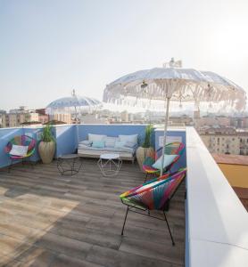 a patio with chairs and an umbrella on a roof at Apartamentos Avenue Rooms in Málaga