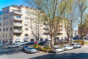 Un estacionamiento con autos estacionados frente a un edificio. en Comfort Rooms Piazza Mariano Armellini, en Roma