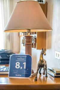 a clock sitting on a table next to a lamp at Hotel Kent in Rome