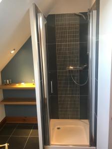 a shower with a glass door in a bathroom at Kimcraigan B&B in Brackla