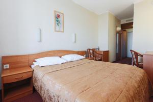 a bedroom with a large bed and a table and chairs at Hotel Meridian in Chelyabinsk