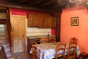a kitchen with a table and a sink and a stove at Casa Rural La Torre de Espinama in Espinama